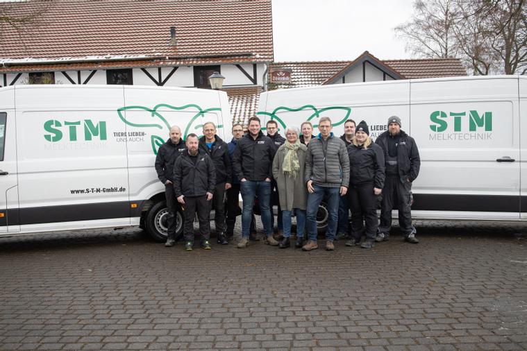 Teambild vor Firmenfahrzeugen