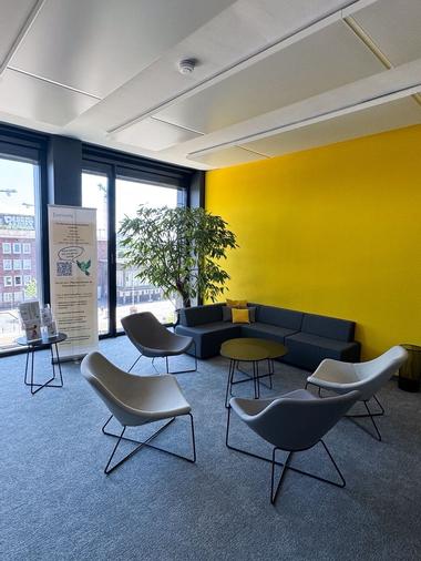 Der Blick in unseren Eingangsbereich zeigt eine moderne, lichtdurchflutete Atmosphäre – mit gemütlichen Sitzmöglichkeiten für Gäste und Mitarbeitende.