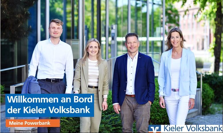 Vier lächelnde Mitarbeitende im Grünen mit dem Schriftzug Willkommen an Bord der Kieler Volksbank